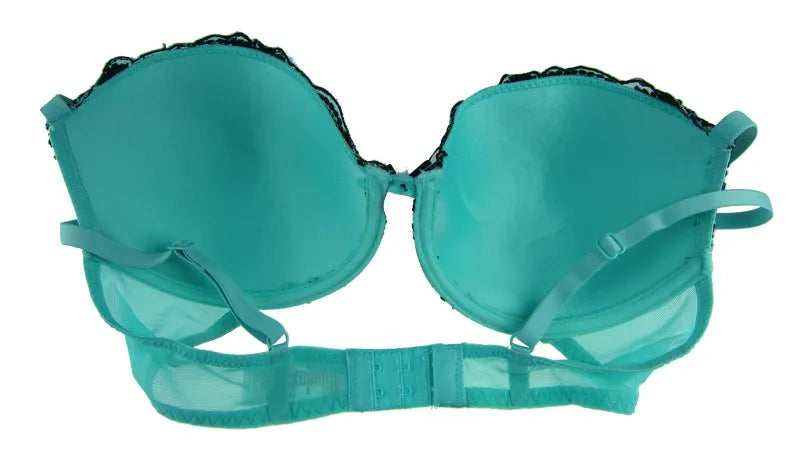 A turquoise green satin and mesh bra with black lace trim and adjustable straps, displayed against a plain white background.