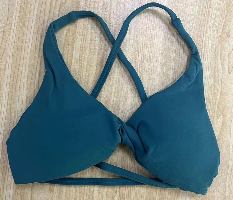 Teal bikini top on a light wooden surface