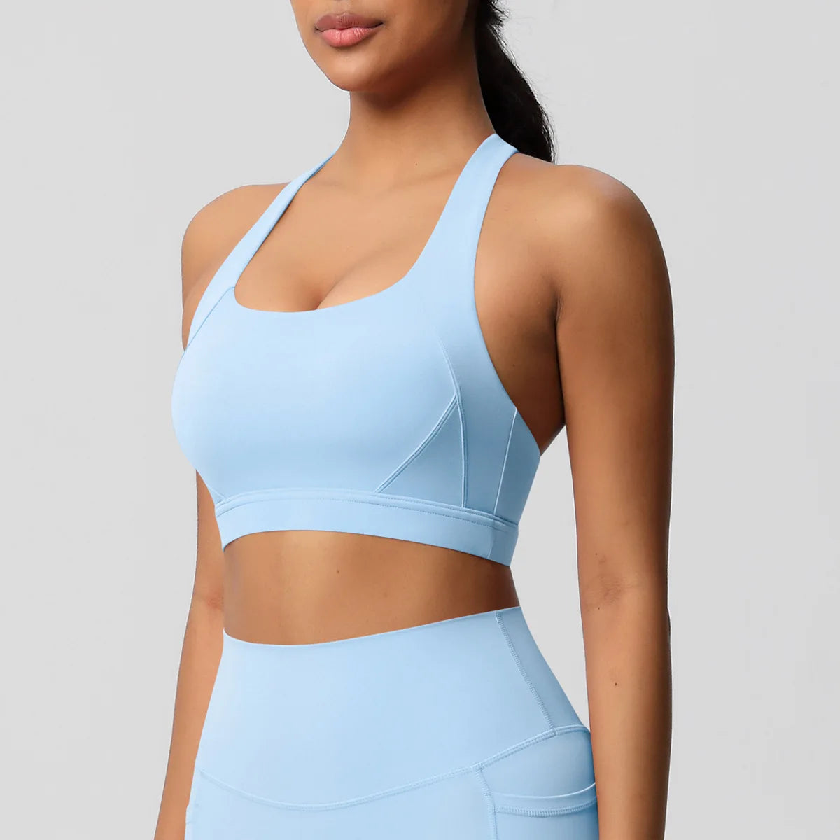 Light blue sports bra and leggings on a plain background