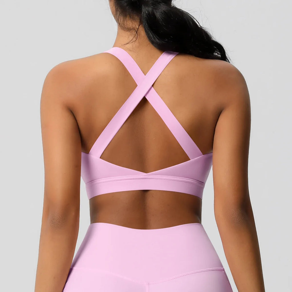 Person wearing a pink sports bra and leggings on a light gray background