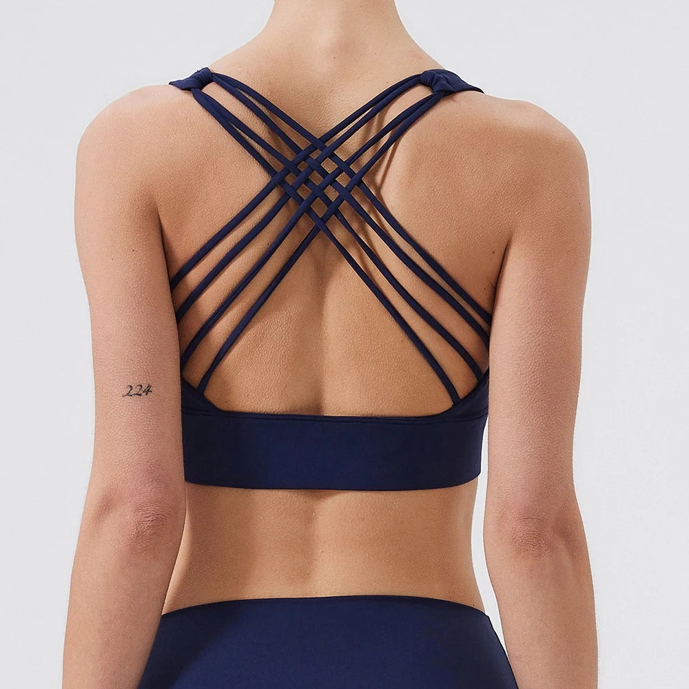 Navy blue sports bra with criss-cross back design on a white background