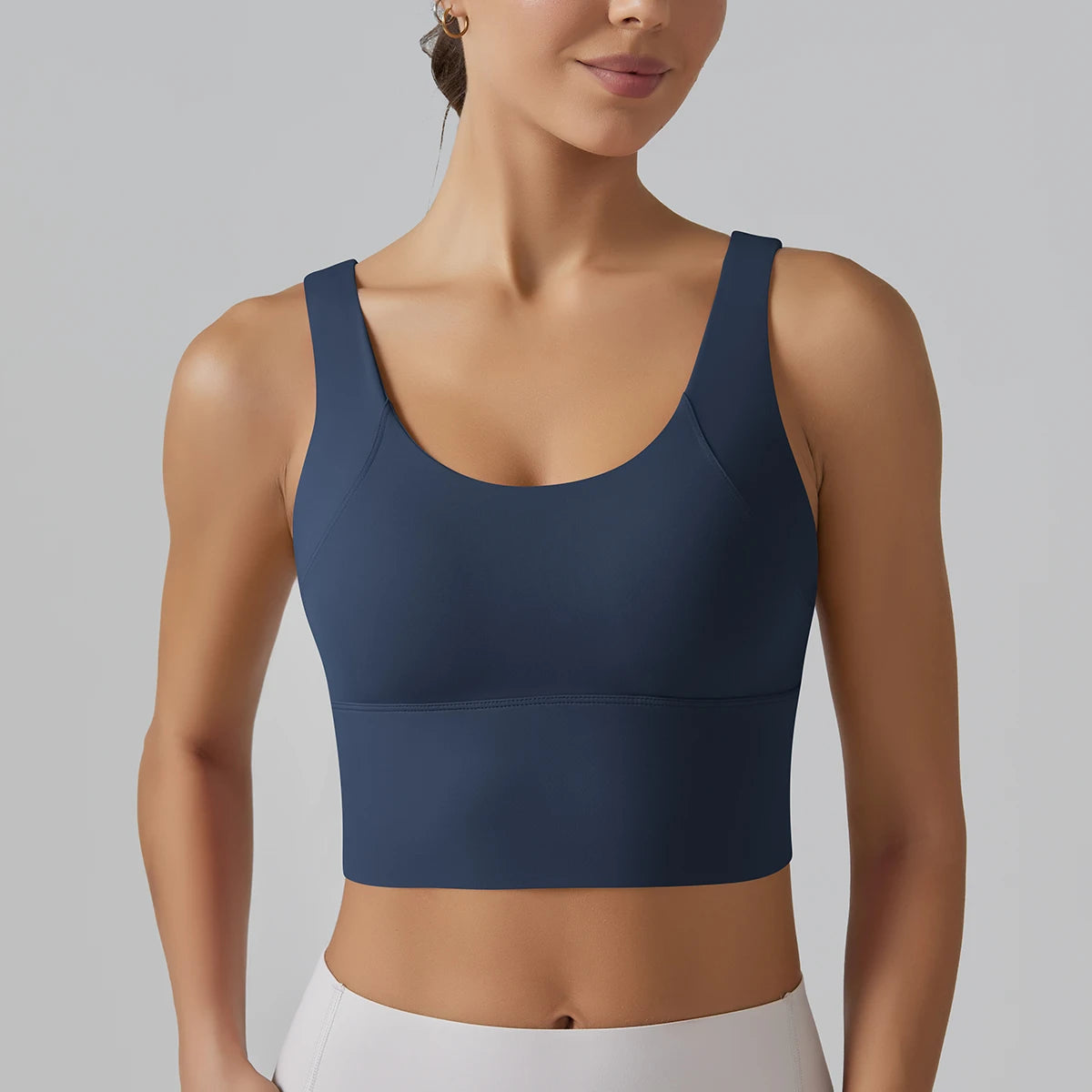 Woman wearing a navy blue sports bra against a gray background