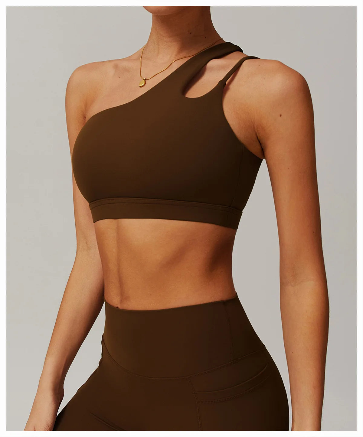 Person wearing a brown sports bra and leggings on a plain background
