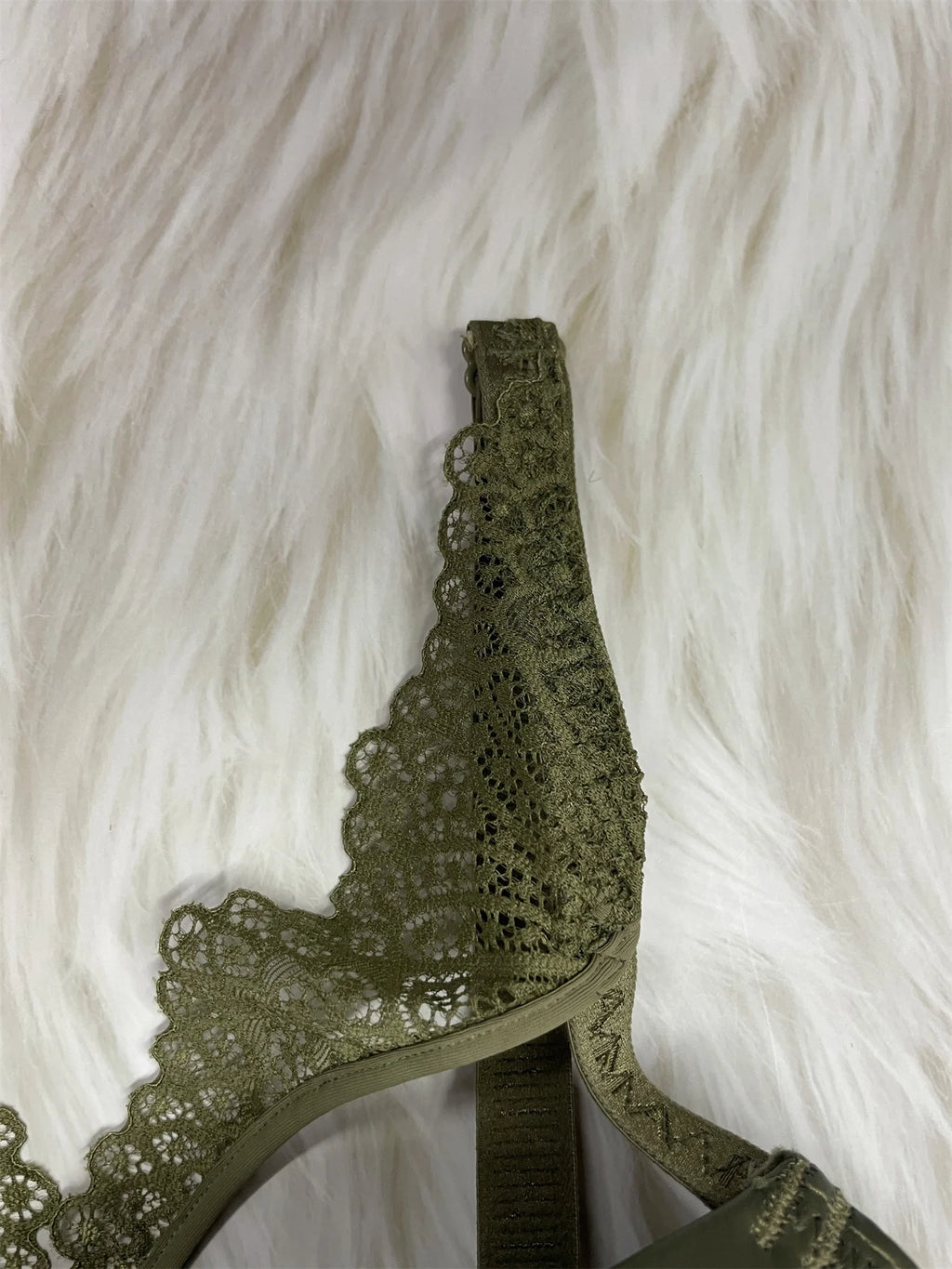 Green lace bralette on a white fur background