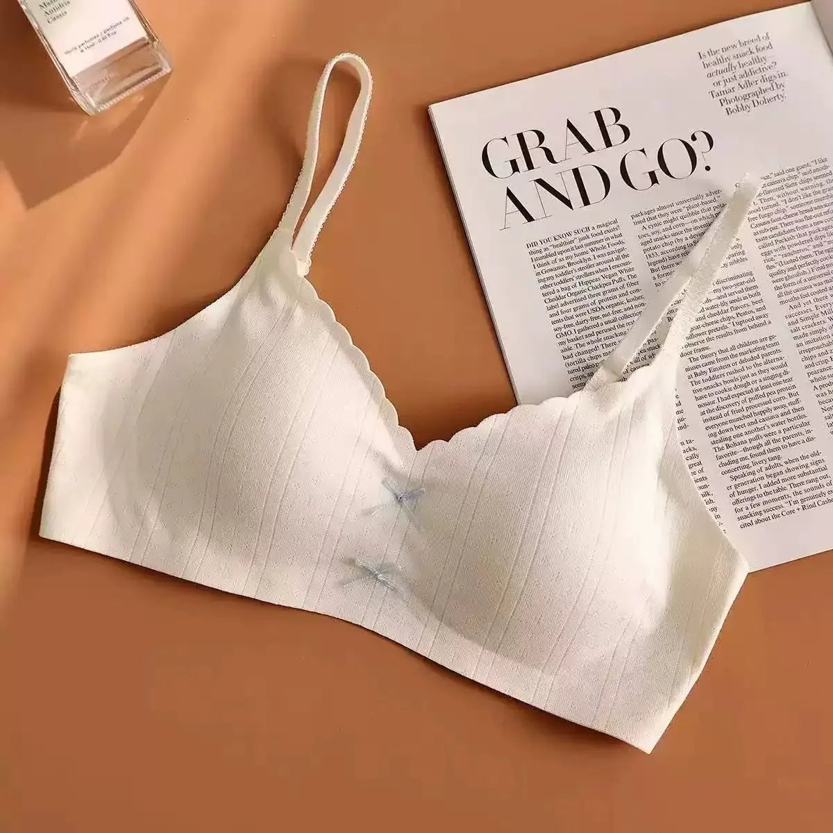White bra on a brown surface with a magazine underneath
