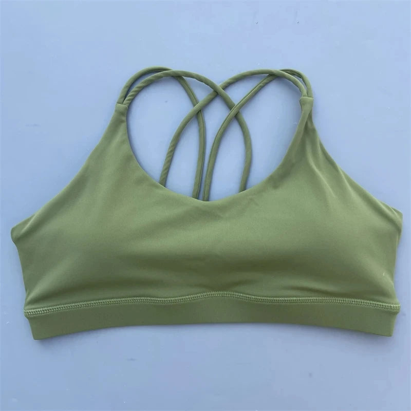 Green sports bra with criss-cross straps on a light blue background