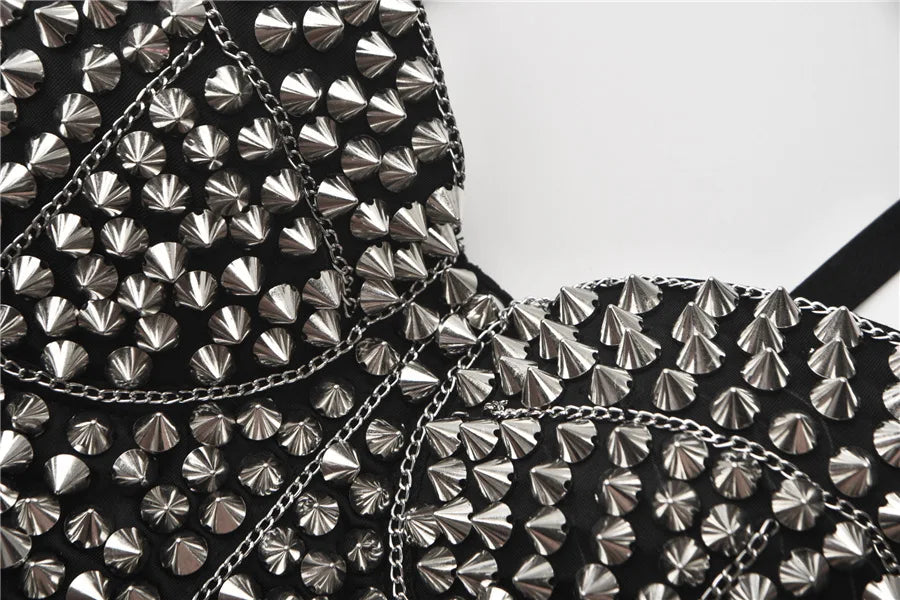 Close-up of a black garment with silver studded details on a white background