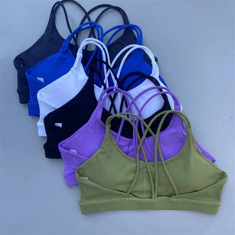 Collection of colorful sports bras on a light gray background