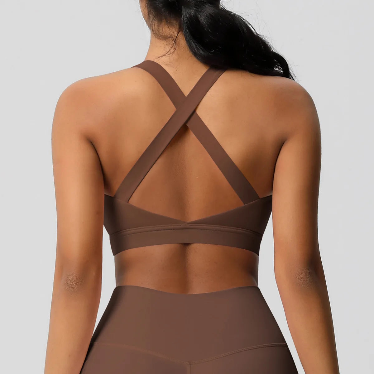 Brown sports bra and leggings on a plain background