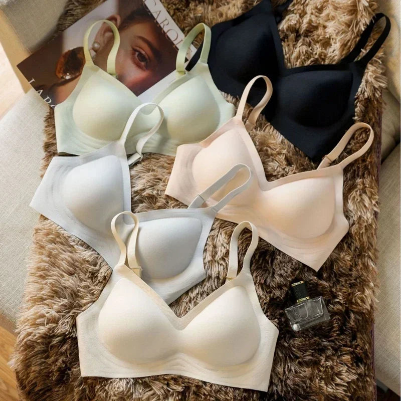 Collection of bras in various colors on a textured surface with a magazine in the background.