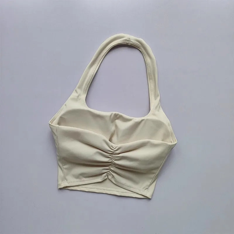 Beige crop top with thin straps on a light gray background
