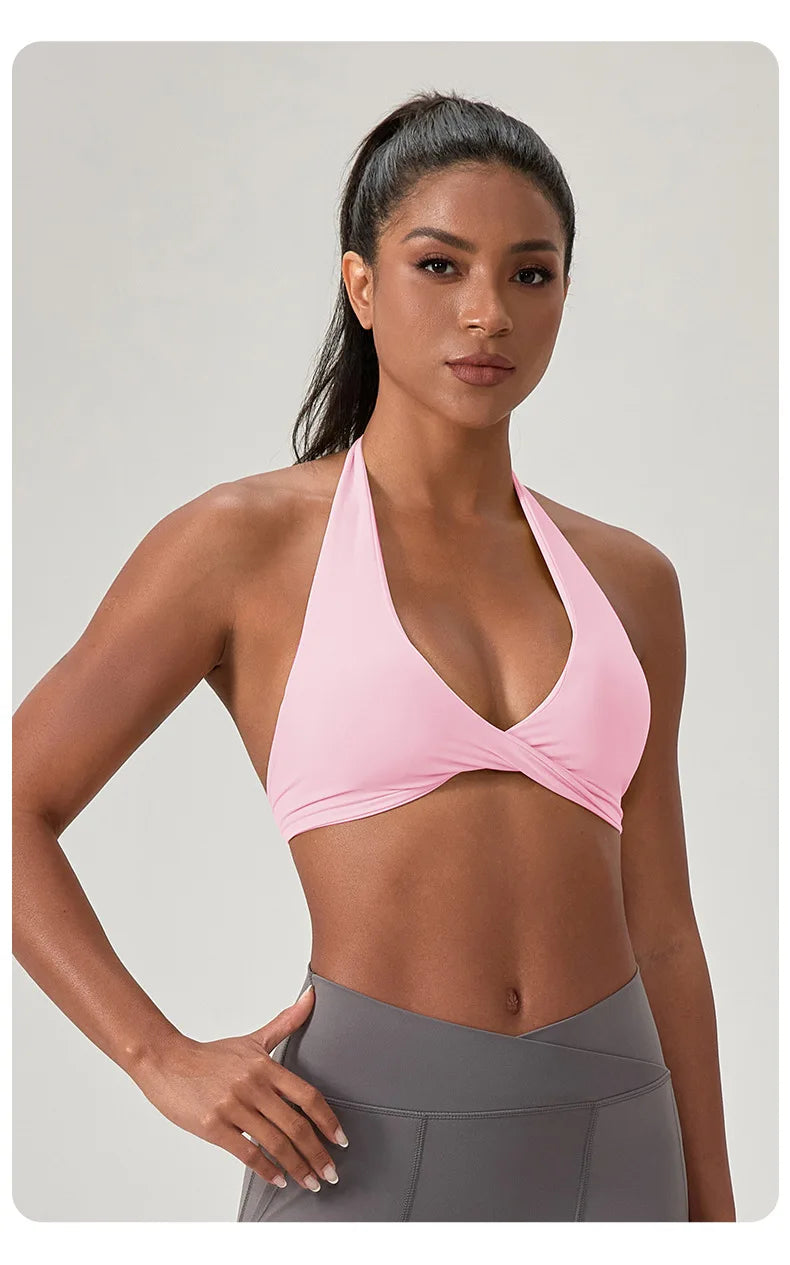 Woman wearing a pink sports bra and gray leggings on a light gray background
