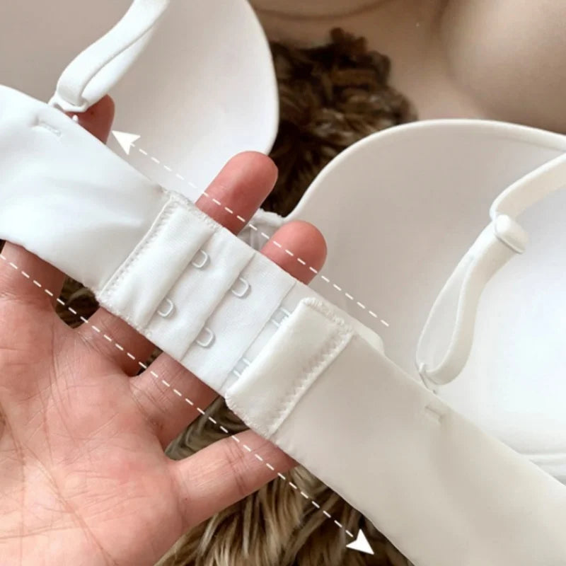 Close-up of a white belt being adjusted by a hand with a neutral background