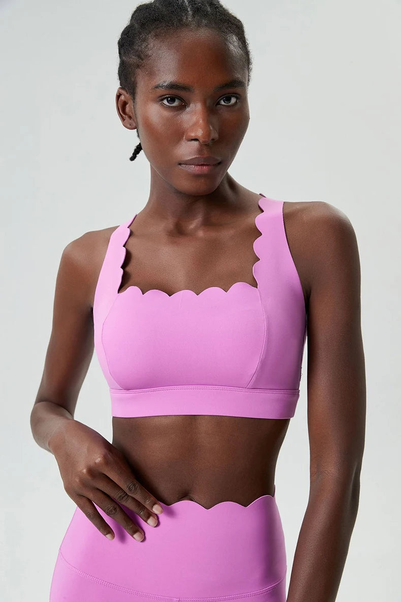 Woman wearing a pink sports bra and leggings on a white background