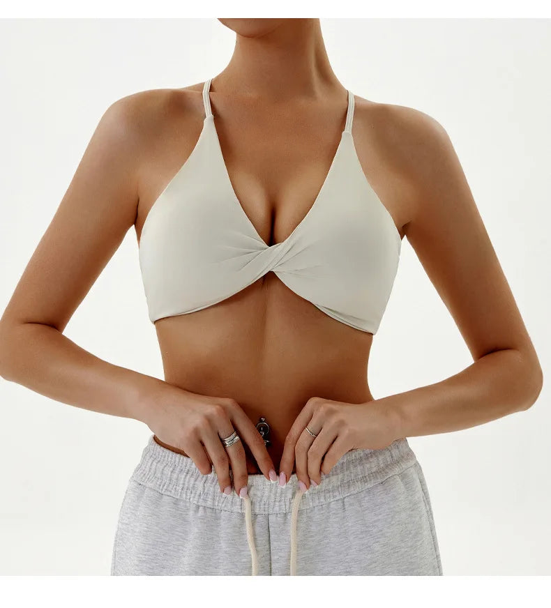 Woman wearing a beige bikini top and gray shorts on a white background