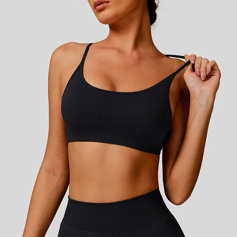 Person wearing a black sports bra and leggings on a plain background