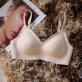 Beige bra on a textured surface with a magazine and perfume bottle in the background