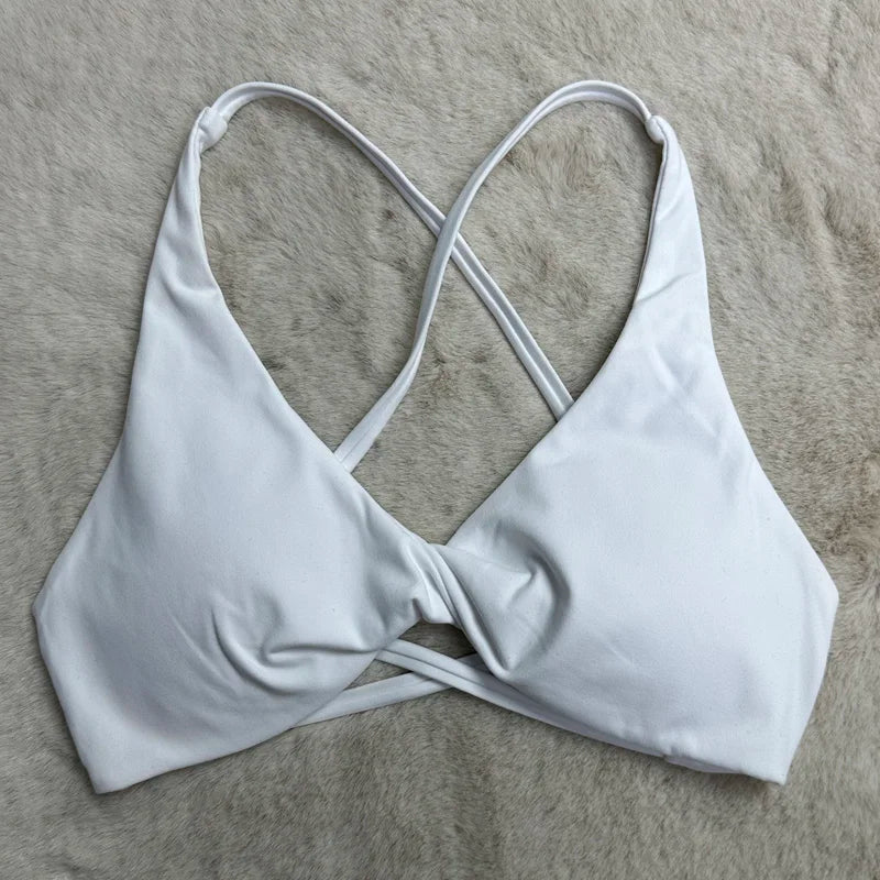White bikini top with criss-cross straps on a gray surface