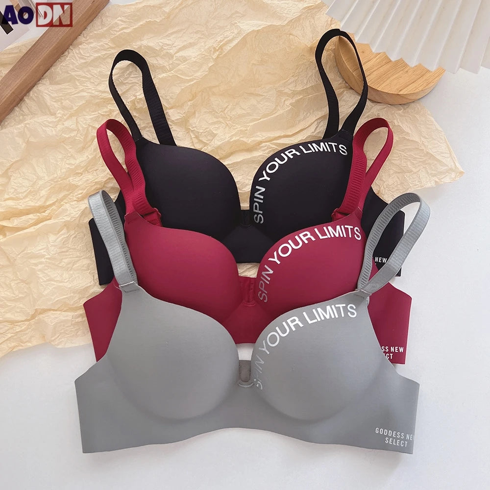 Set of three bras in black, red, and gray with 'SPIN YOUR LIMITS' text on a textured surface.