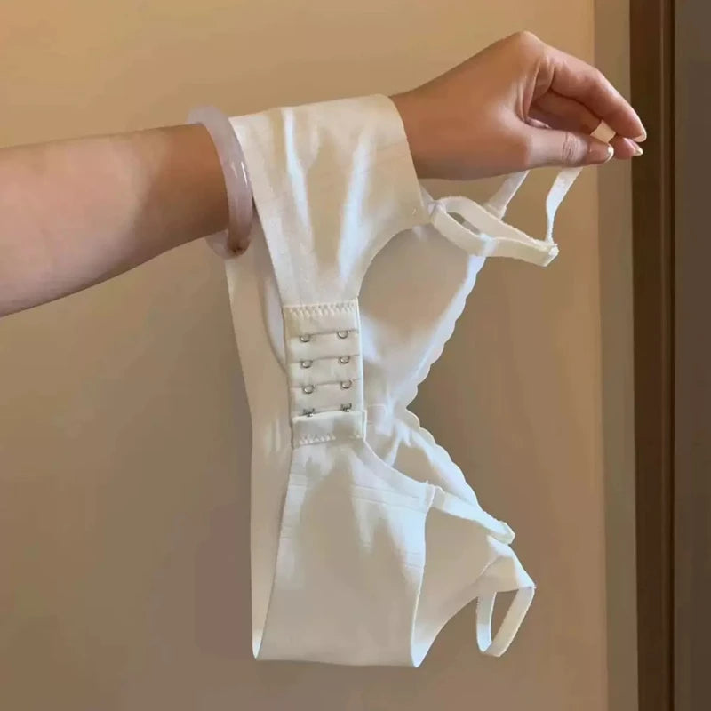 White corset being held by a person against a neutral background