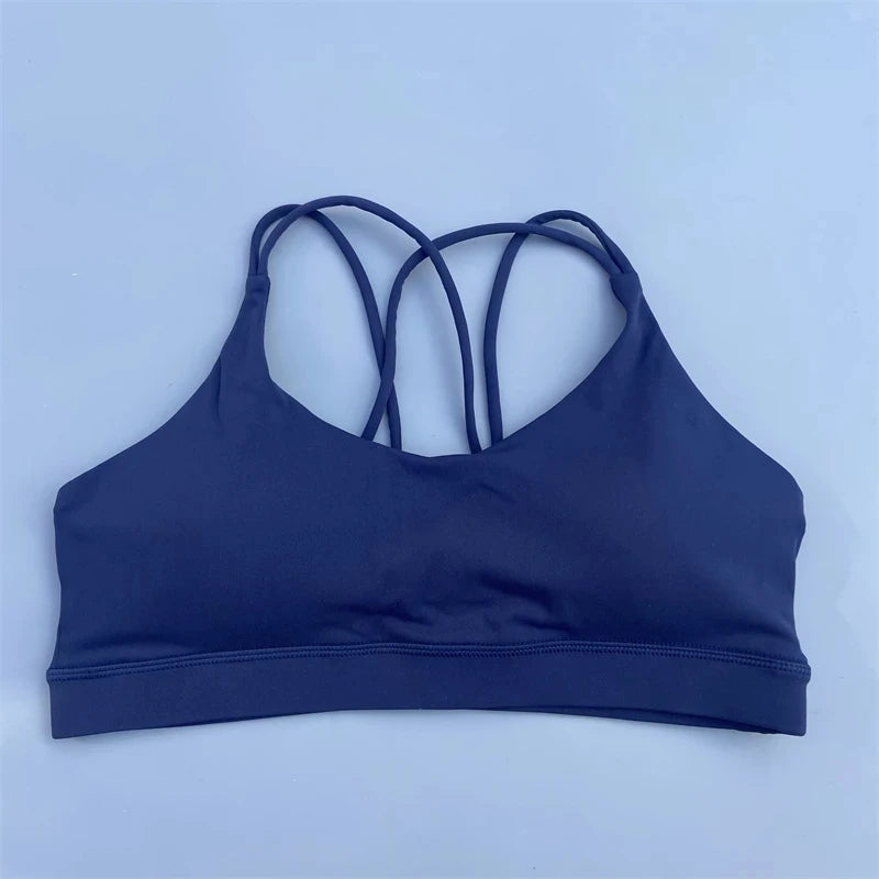 Navy blue sports bra with thin straps on a light blue background