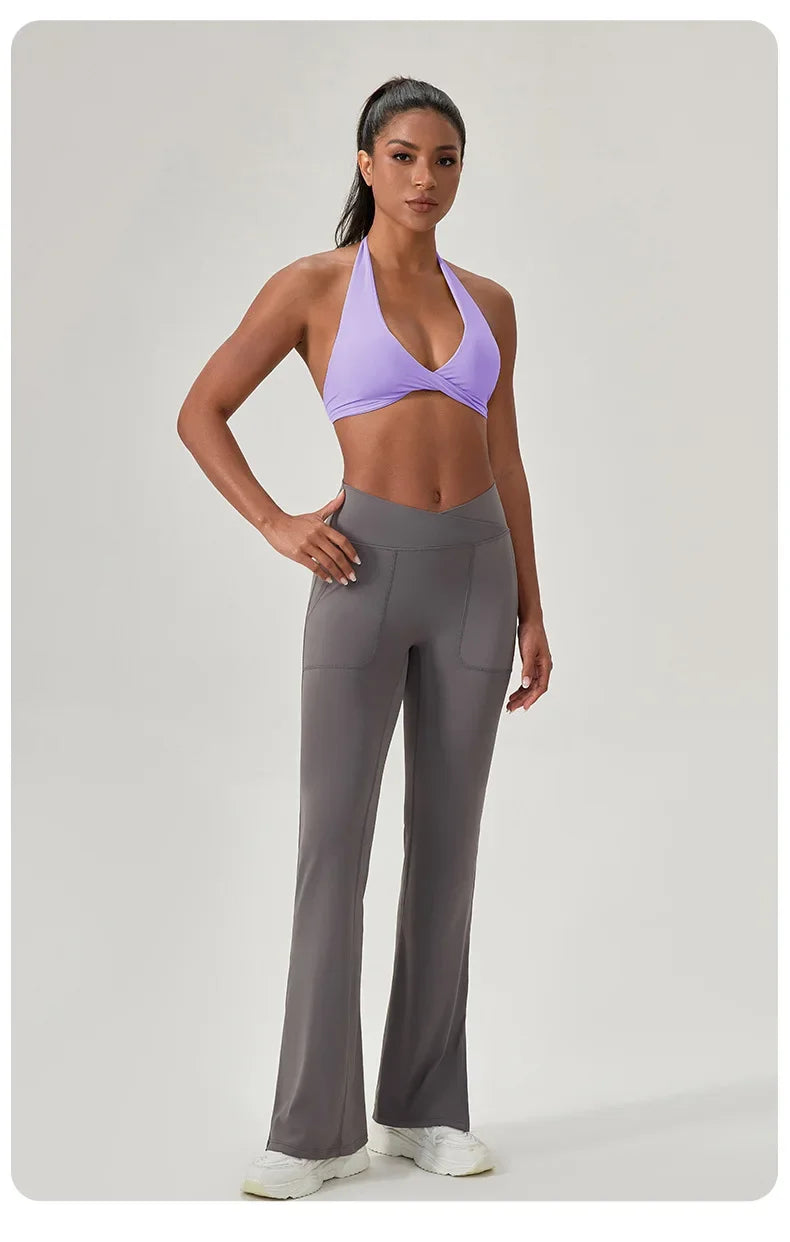 Woman wearing a purple sports bra and gray leggings on a light gray background