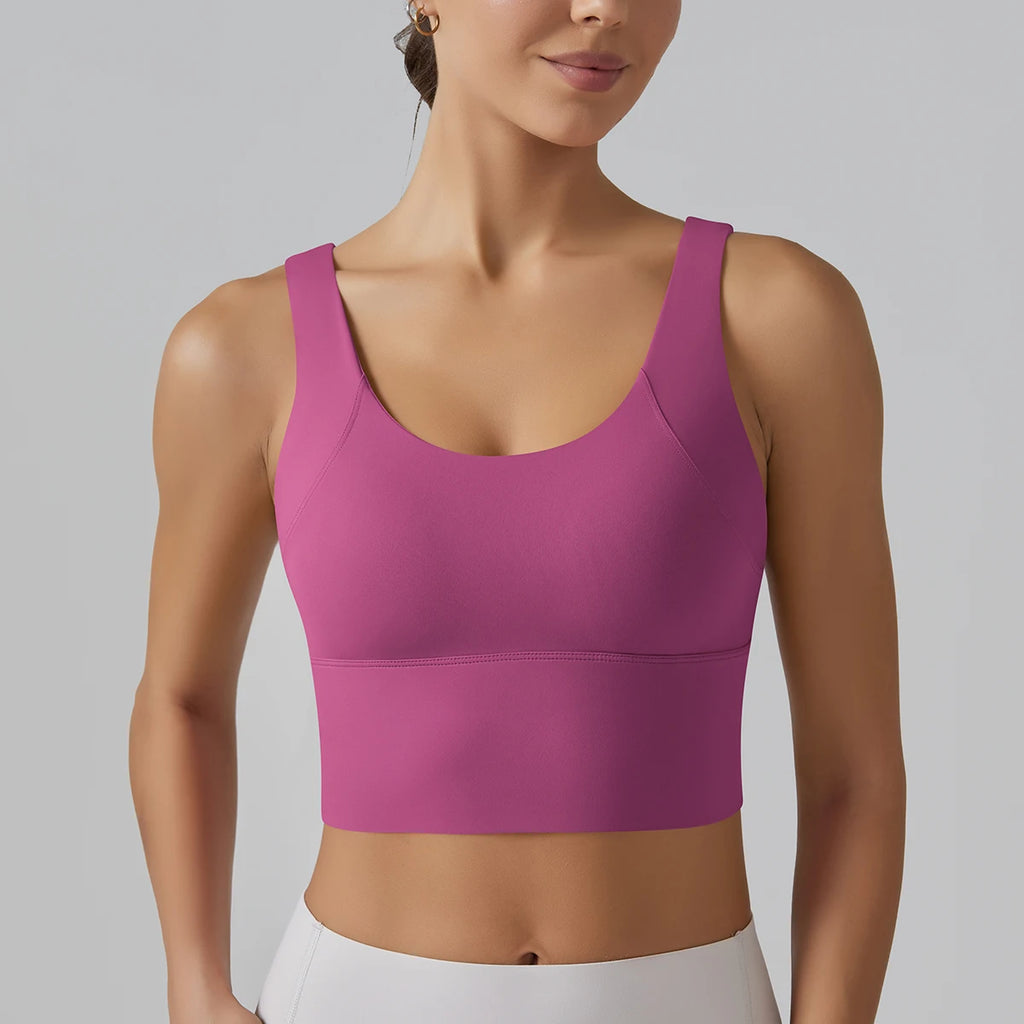 Woman wearing a pink sports bra against a gray background