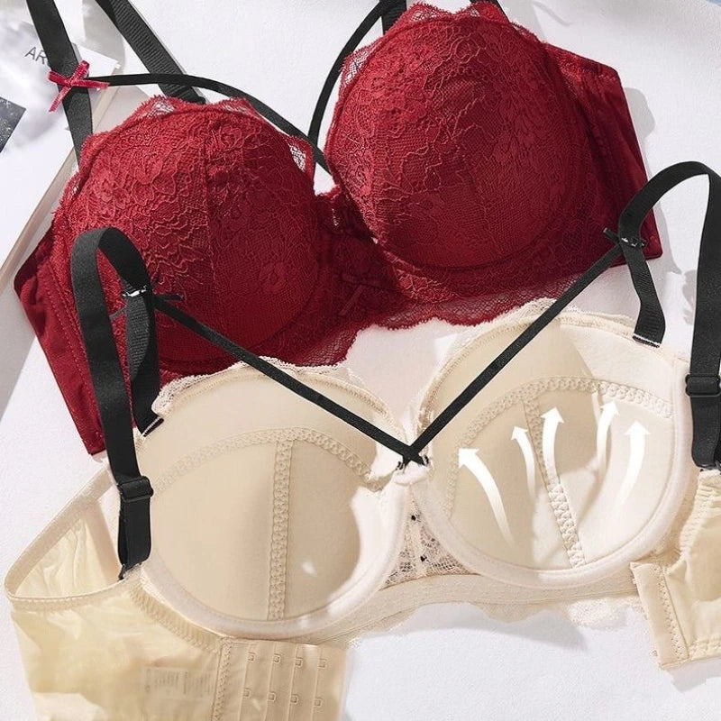 Two lace underwire bras laid flat on a white surface: one deep red and one cream/beige, both with black adjustable shoulder straps.