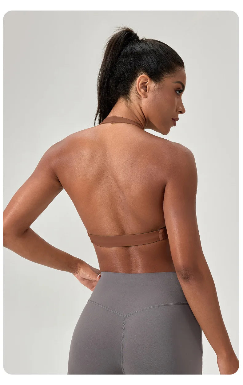 Woman wearing a brown sports bra and gray leggings on a light gray background