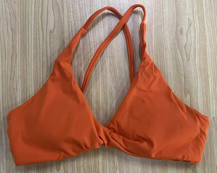 Orange bikini top on a wooden surface