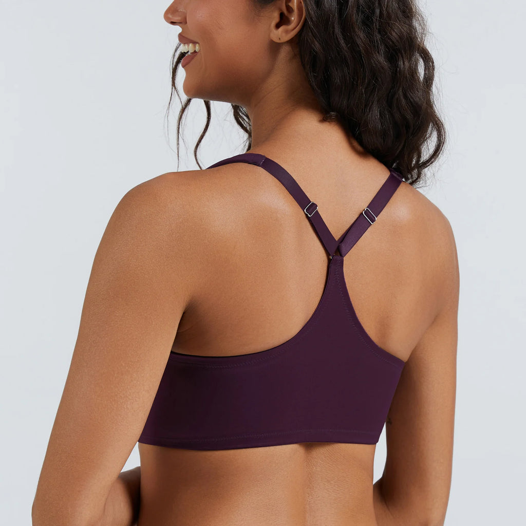 Woman wearing a purple sports bra against a plain background