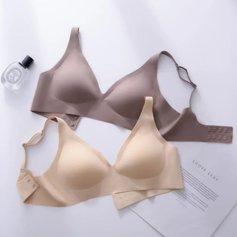 Two bras, one beige and one brown, on a white surface with a magazine underneath.