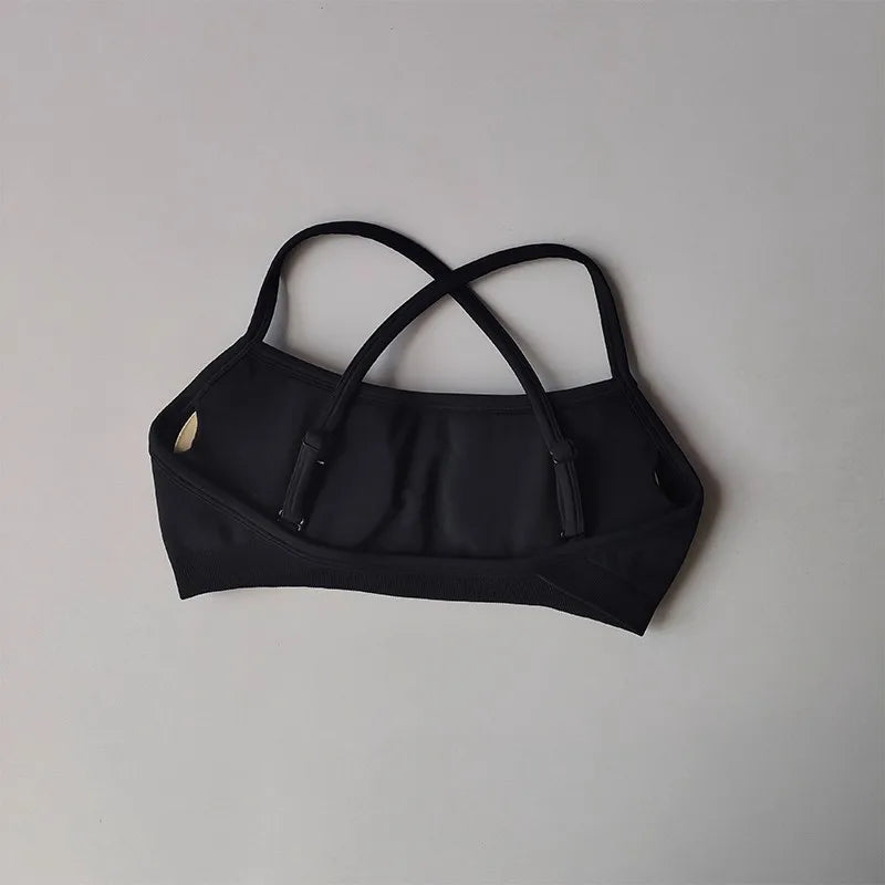 Black bikini top with thin straps on a light gray background