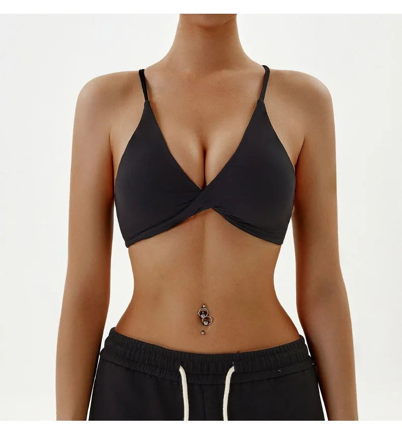 Person wearing a black bra and black pants on a white background