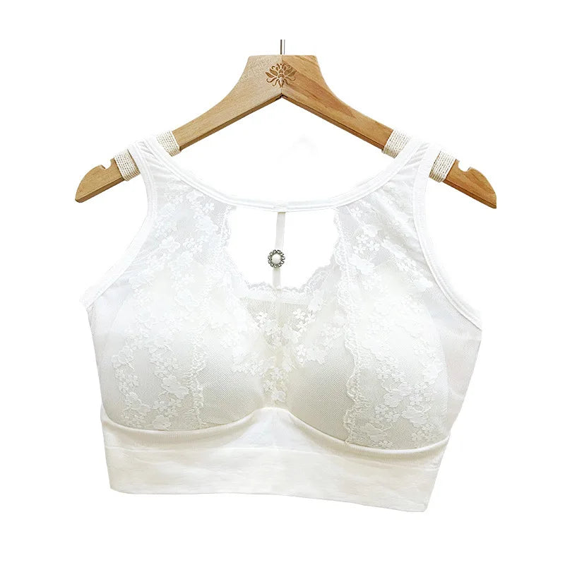 White lace bralette on a wooden hanger against a white background