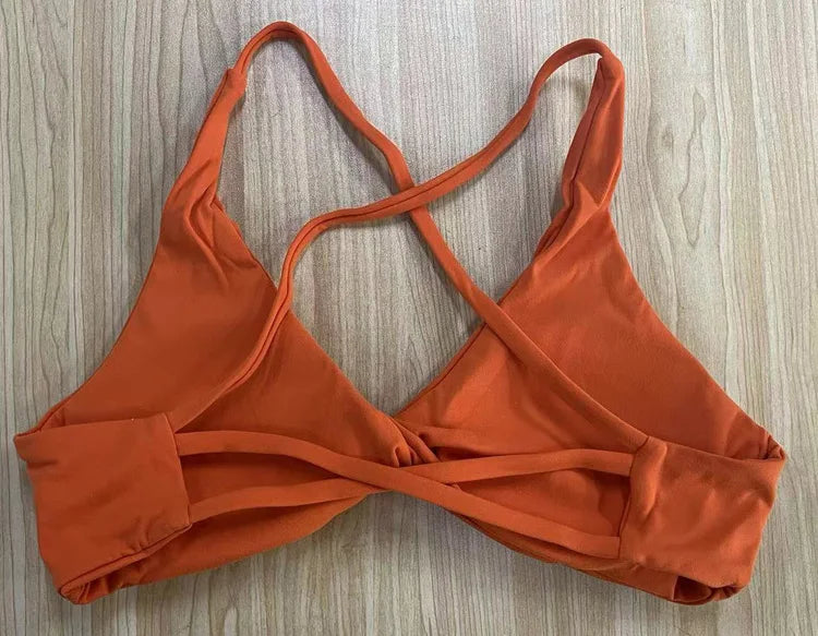 Orange bikini top on a wooden surface