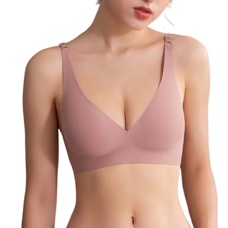 A woman wearing a seamless, V-neck bralette in a dusty rose pink color, shown from the chest down against a plain white background.