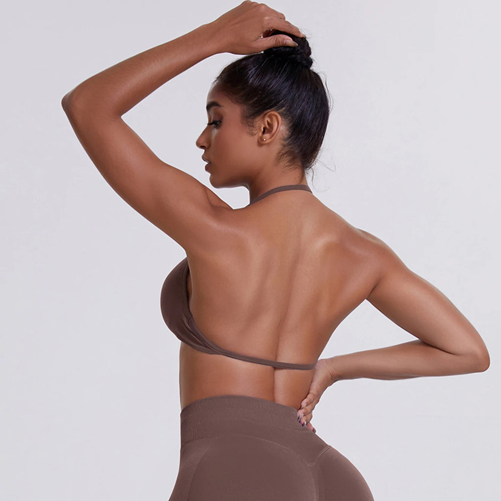Woman in a brown outfit against a plain background