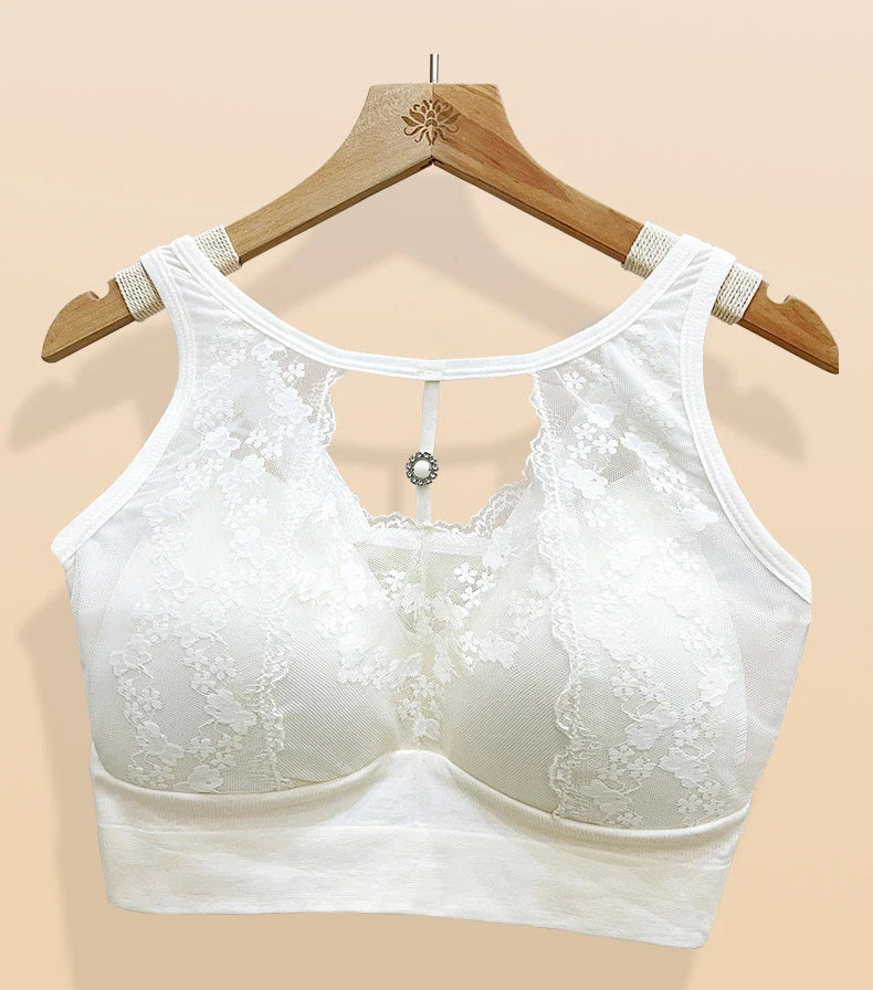 White lace underwire bra displayed on a wooden hanger against a solid beige background.