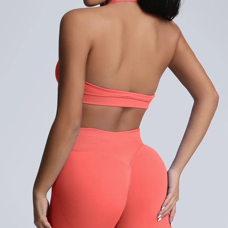 Person wearing a coral sports bra and leggings set on a light gray background