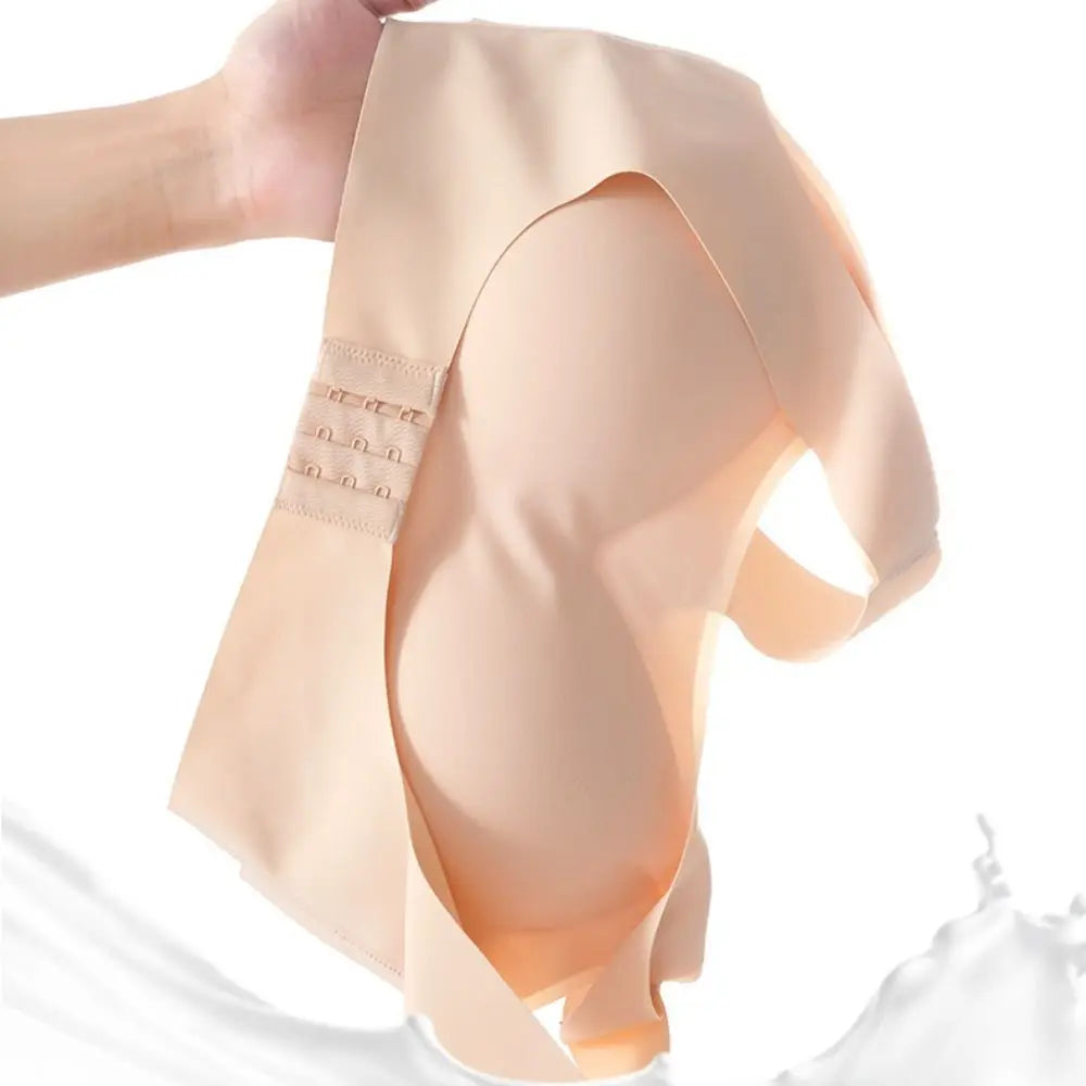 A close-up of a nude beige seamless underwire bra cup being held up by a hand, showing the smooth fabric texture and the triple-hook closure on the side, set against a bright white background with a soft white splash at the bottom.
