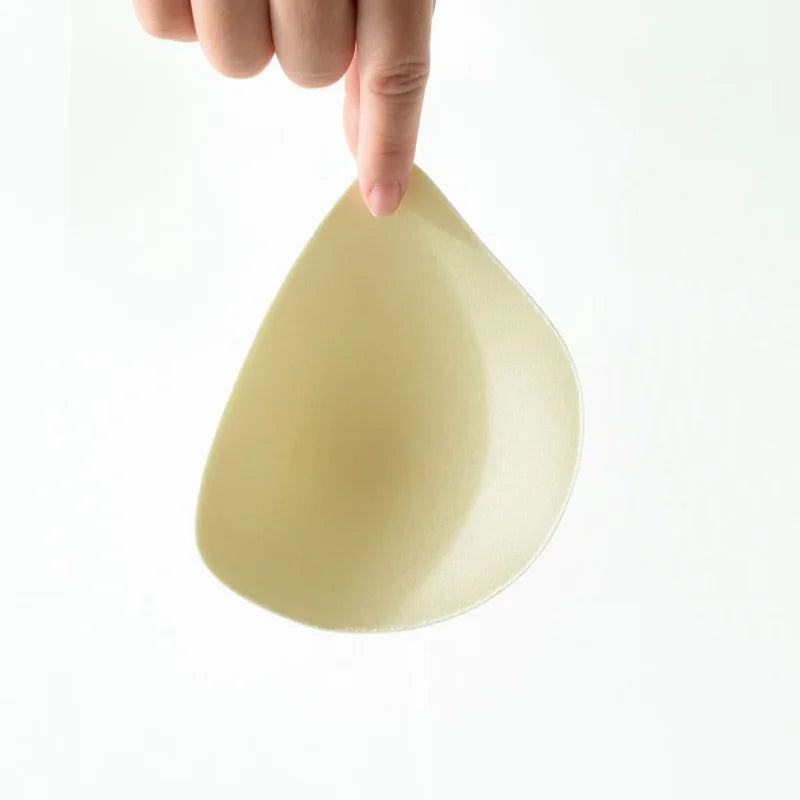 Hand holding a beige ceramic bowl against a white background