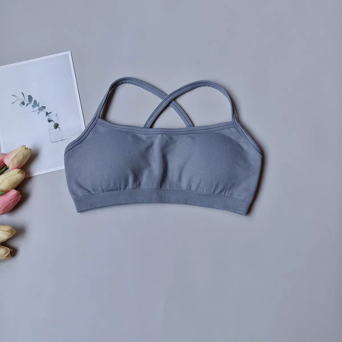 Gray bralette on a light gray background with tulips and a card.
