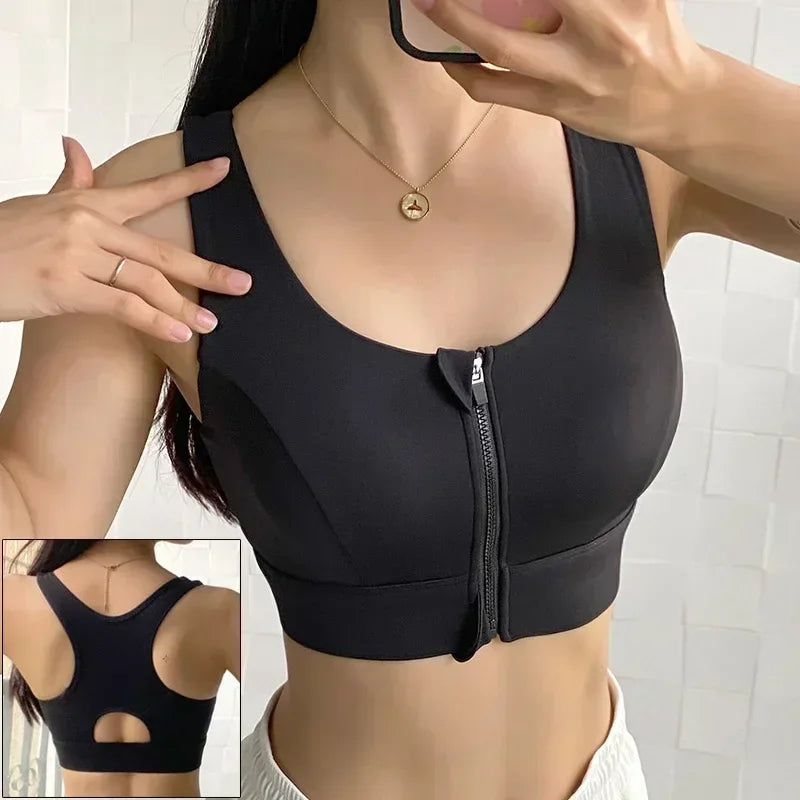 Black sports bra with a zipper detail worn by a person, with a bathroom background.