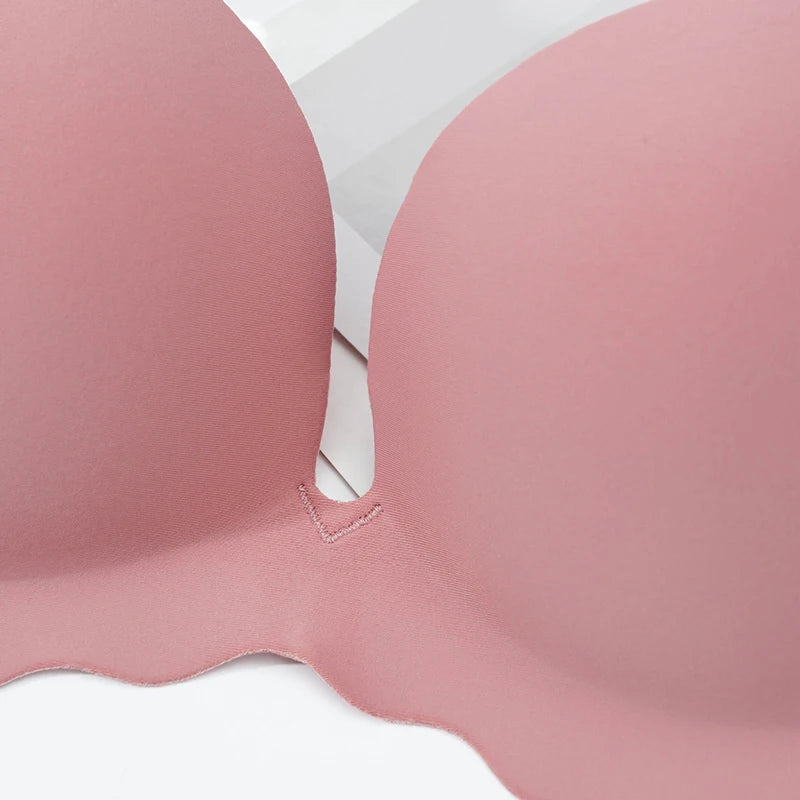 Close-up of a soft pink seamless underwire bra cup on a white background.