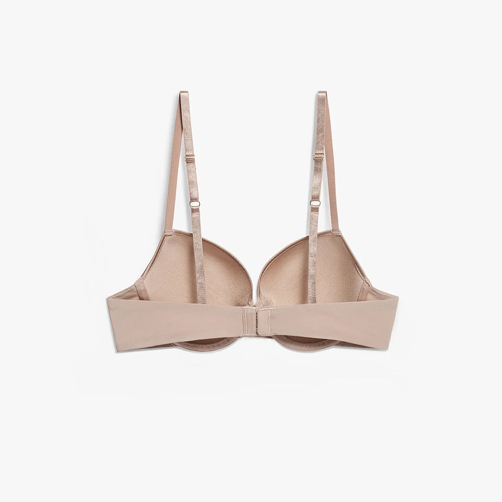 A light beige wireless underwire bra with wide shoulder straps and a center gore, shown from the front on a light gray background.