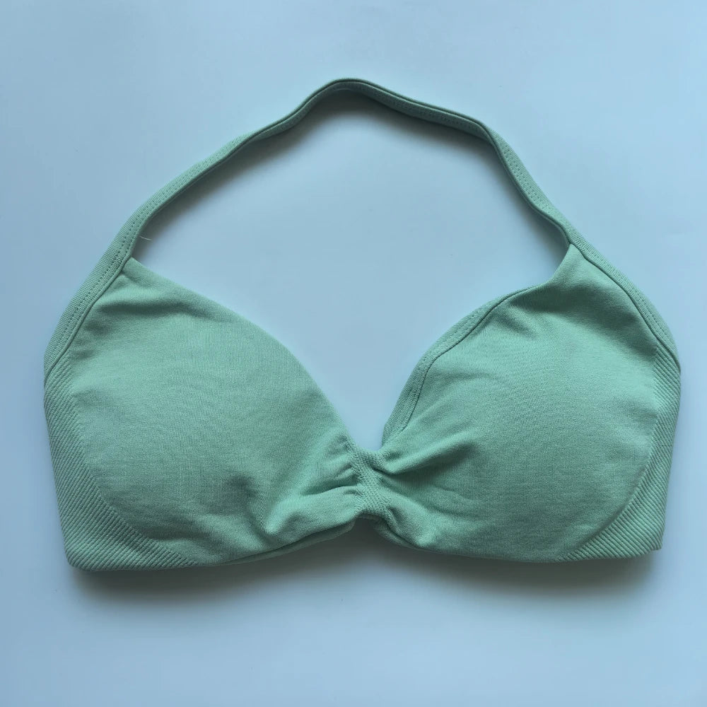 Green bikini top on a light blue background