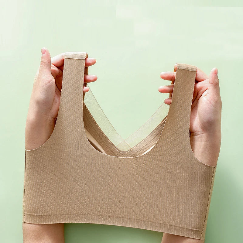 Beige tank top held up against a light green background