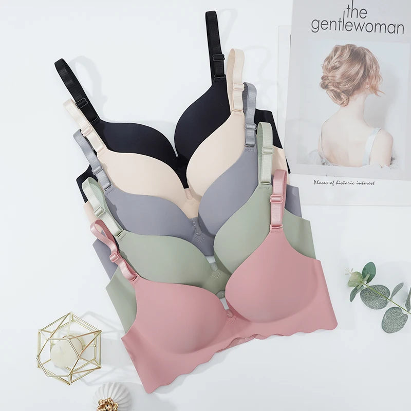 Set of women's bras in various colors on a white background with a magazine featuring a woman in lingerie.