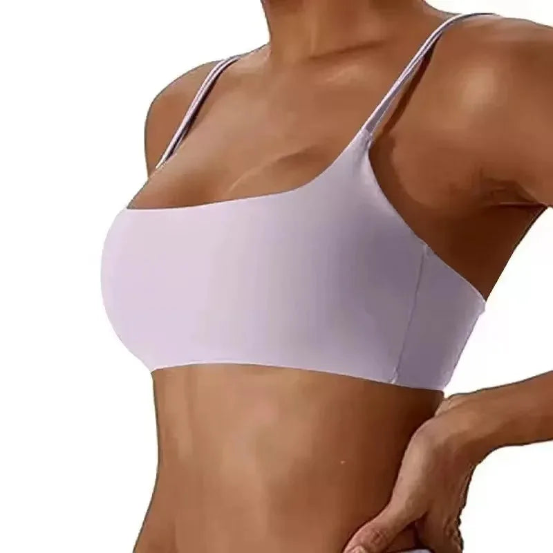A close-up of a woman wearing a light lavender wireless bra with thin straps against a plain white background.